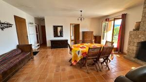 una sala da pranzo con tavolo e sedie di La Castagna Sea View Pool Villa a Coti-Chiavari