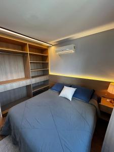 um quarto com uma cama grande com travesseiros azuis em Apartamento Descolado Zona Norte em Boa Vista
