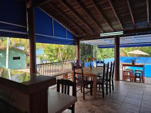 a dining room with a table and chairs on a deck at Temporada Belas Casas in São Pedro