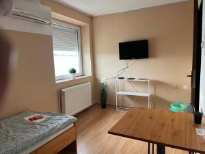 a living room with a table and a television at Sobe Zoka in Subotica