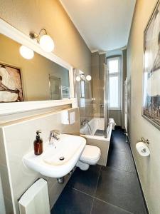 Un baño con lavabo, inodoro y bañera. en primeflats - Apartments Genter Berlin-Wedding, en Berlín 21 fotos más