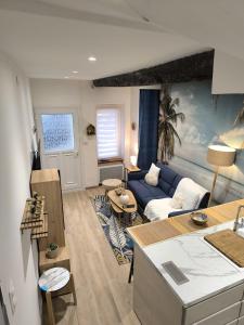 a living room with a blue couch and a table at L'horizon De Coursan in Coursan