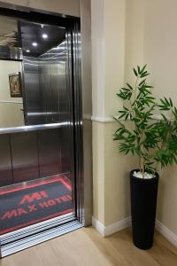 a potted plant sitting next to a glass door at Max Hotel in Brasília