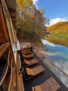 a group of wooden benches on the side of a river at Pablo's place in Rezine