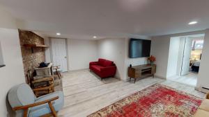 a living room with a red couch and a tv at Winter Lore in Mendon