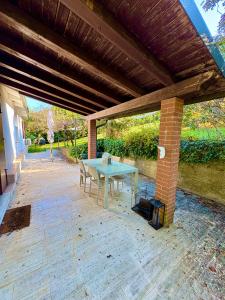 PeraroloにあるB&BCB - B&B Colli Bericiのレンガ造りの建物で、パティオ(テーブル付)