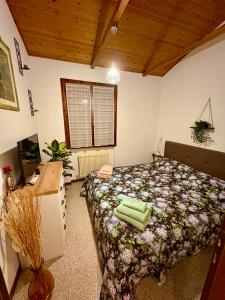 PeraroloにあるB&BCB - B&B Colli Bericiのベッドと机と窓のある寝室