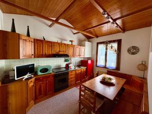 a kitchen with wooden cabinets and a table in it at Casetta La Pera in Perarolo