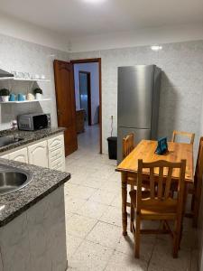 a kitchen with a wooden table and a stainless steel refrigerator at Casa Sole in El Médano +7 photos