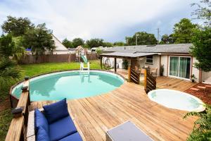 a backyard pool with a wooden deck and a swimming pool at Light & Cozy Oasis in Jacksonville