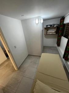 a living room with a white wall and a floor at Pousada Morada das Nações in Balneário Camboriú