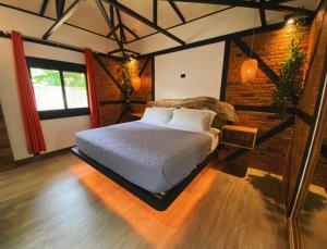 a bedroom with a bed and a brick wall at Buendía Lux Lotus Suite Hidden Gem Near Beach with Pool in Potrero +20 photos