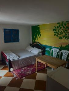 a bedroom with a bed and a table and chairs at Laverie du Soleil Surf House in Taghazout +14 photos