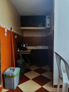 a small kitchen with a checkered floor at Laverie du Soleil Surf House in Taghazout
