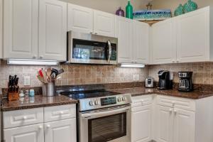 a kitchen with white cabinets and a stove top oven at Turnberry 8573 in Destin +32 photos