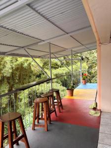 a row of tables and stools on a patio at Hospedaje Angeluz in Quesada