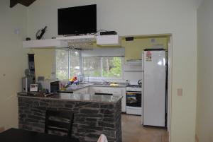 a kitchen with a white refrigerator and a sink at Casa Mar de Ostende 3 Dormitorios 8 Pasajeros in Ostende +4 photos