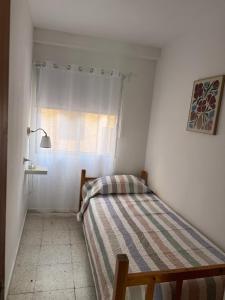 a small bedroom with a bed and a window at Casa Sole in El Médano