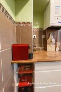 une cuisine avec un comptoir et un appareil rouge dans l'établissement Magnifique Appartement du Vieux Boucher 3 chambres à Alençon, à Aleçon 14 autres photos