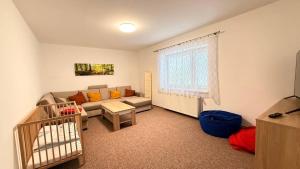 Una sala de estar con un sofá y una cuna. en Chata Vápenná, en Jeseník
