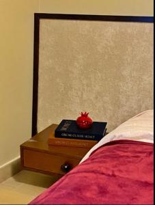 Una mesita de noche con un libro y un tomate encima. en The Poet Den with 120 inch screen, en Yas Island 4 fotos más