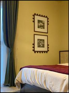 Un dormitorio con una cama y dos cuadros en la pared. en The Poet Den with 120 inch screen, en Yas Island