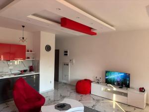 a living room with a red chair and a television at Red room in Petrovac na Mlavi