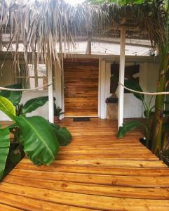a wooden walkway leading to a house with a thatch roof at Buendía Lux Lotus Suite Hidden Gem Near Beach with Pool in Potrero
