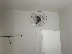 a fan hanging on a wall next to a door at Suíte 16 no centro da cidade in Uberaba