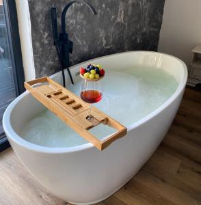 una bañera con una copa de vino. en EleS Chalet, en Brebu