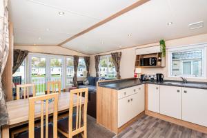 a kitchen and living room with a table and chairs at 3 Bedroom Static Caravan-Seton Sands in Port Seton +34 photos