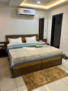 a bedroom with a large bed with a air conditioner on the wall at The Royal palace hotel in Phalodi