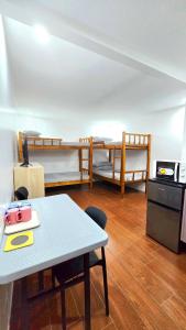 a room with two bunk beds and a table at Studio Units near Airport by Jade Studio Apartments in Manila