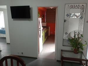 a kitchen with a door leading into a kitchen with a television at La casa de Emma in Córdoba
