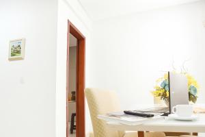 a white table with a laptop computer on it at Apartamento completo e bem localizado 302 in Vitória da Conquista +26 photos