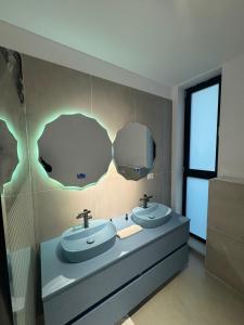 een badkamer met twee wastafels en een spiegel bij Knight Home in Voluntari