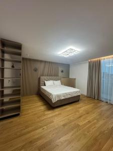 een slaapkamer met een bed en houten vloeren bij Knight Home in Voluntari