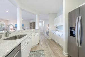 a kitchen with white cabinets and a stainless steel refrigerator at Turnberry 8561 in Destin +49 photos