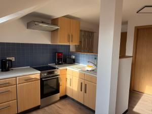 een keuken met houten kasten en een kookplaat met oven bij Ferienwohnungen in Röblingen 