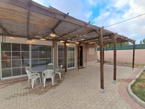 un patio con mesa y sillas bajo una pérgola en Casa Velha, en Pêra