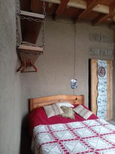Schlafzimmer mit einem Bett mit einer roten und weißen Decke in der Unterkunft Lodge Malezas del Desierto in Los Choros + 15 Fotos