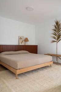 a bedroom with a bed with a wooden headboard at Casa Tester by FTV HOLIDAYS HOMES in Villaverde