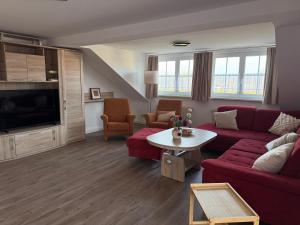 een woonkamer met een rode bank en een tafel bij Ferienwohnungen in Röblingen 