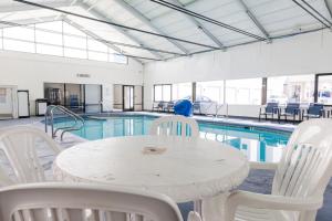 a table and chairs in front of a swimming pool at Ramada Plaza by Wyndham Virginia Beach Oceanfront in Virginia Beach