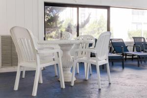 a white table and chairs in a room at Ramada Plaza by Wyndham Virginia Beach Oceanfront in Virginia Beach
