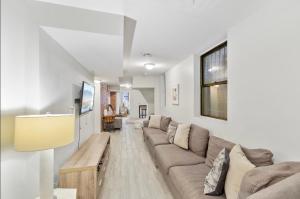 a living room with a couch and a table at designer abode condo min to Manhattan in jersey city in Jersey City