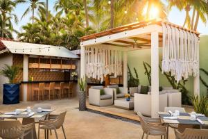 a patio with tables and chairs and a restaurant at Sunscape Dorado Pacifico Ixtapa Resort & Spa- All Inclusive in Ixtapa