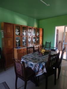 a dining room with a table and chairs and green walls at FICOS Hospedagem in São Gabriel