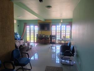 a room with chairs and a living room with windows at FICOS Hospedagem in São Gabriel