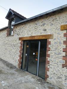 a brick building with a sliding glass door at Gîte Beauséjour in Saint-Aubin-de-Luigné